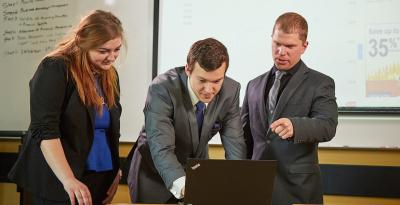 Business students gathered around a laptop