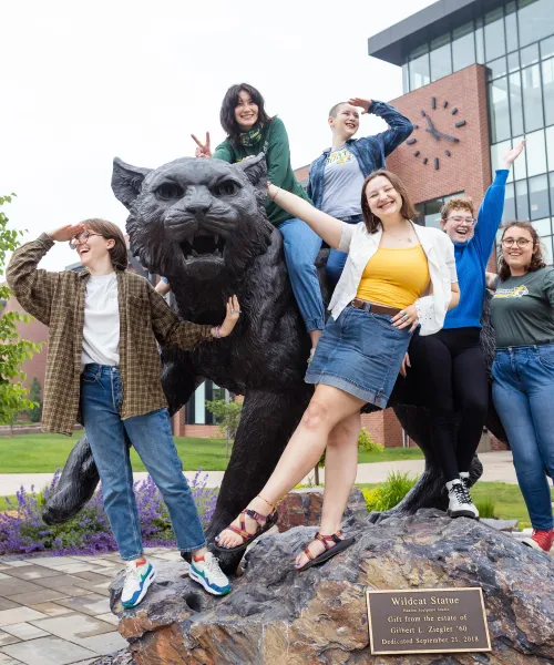 NMU students with the Wildcat Statue on campus